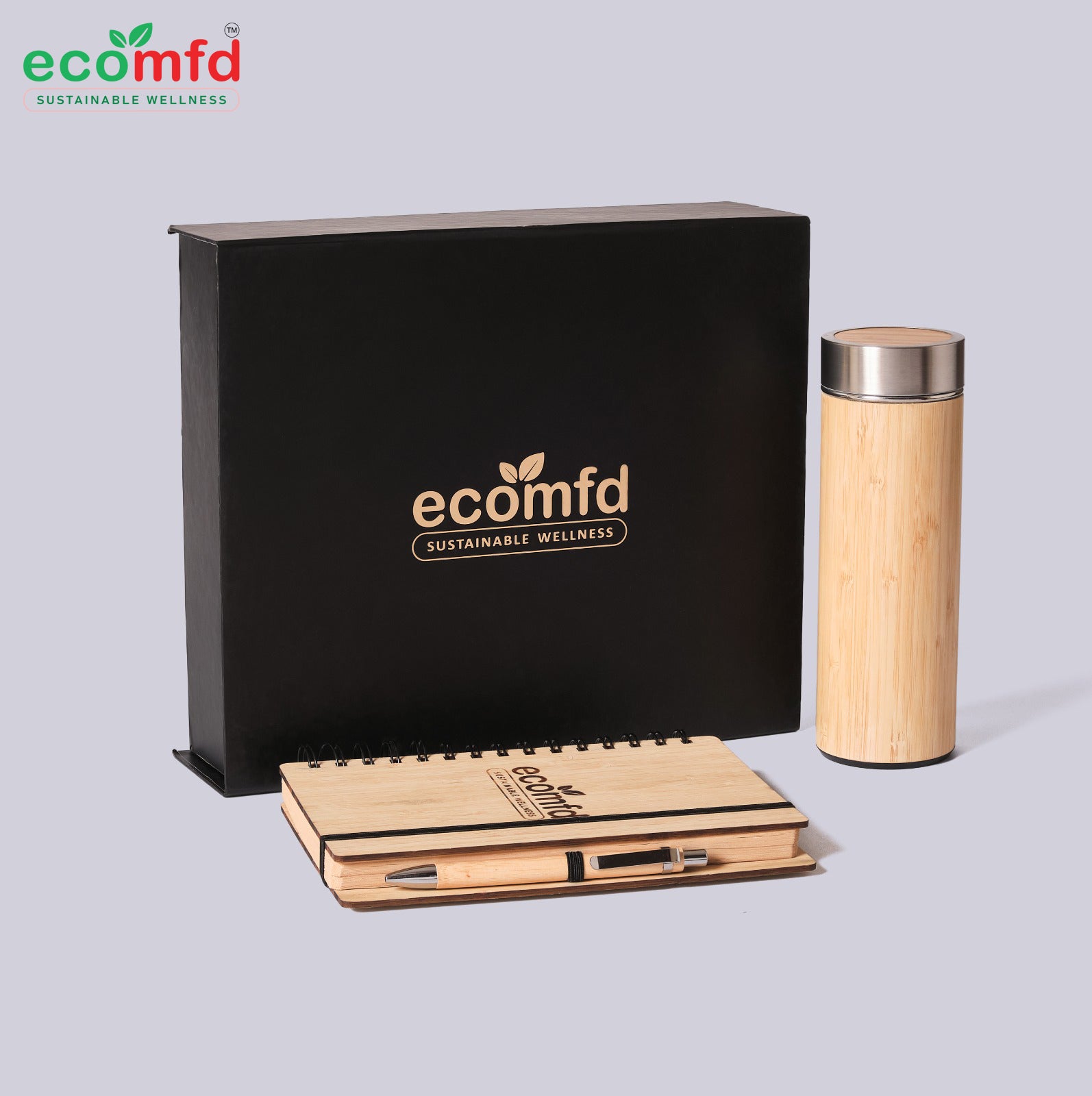 Bamboo notebook and tumbler with ecomfd branding on a light gray background